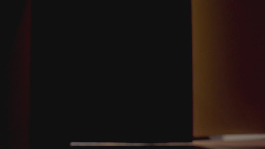 Nő örömmel kiveszi a terméket a dobozból, átvesz egy csomagot a futártól, majd mosolyogva forgatja a csomagot az asztalon.