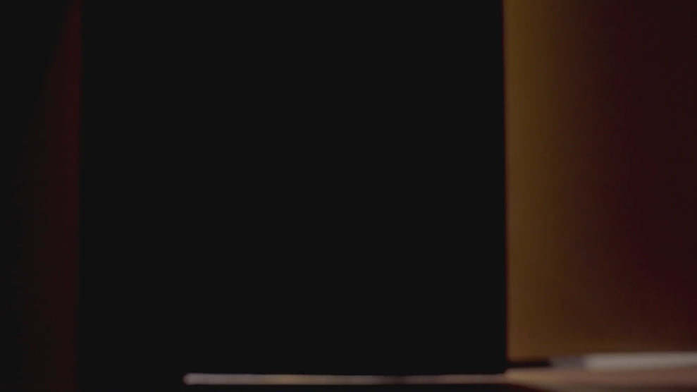 Nő örömmel kiveszi a terméket a dobozból, átvesz egy csomagot a futártól, majd mosolyogva forgatja a csomagot az asztalon.