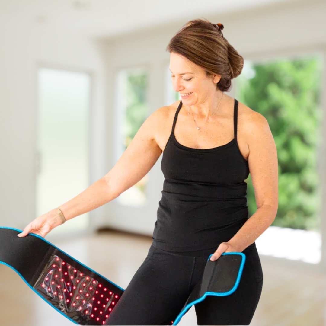 Idősebb hölgy otthon vörös fényterápiás szalaggal; fájdalomérzet csökkentése és bőrkomfort javítása, zsírbontás támogatása.